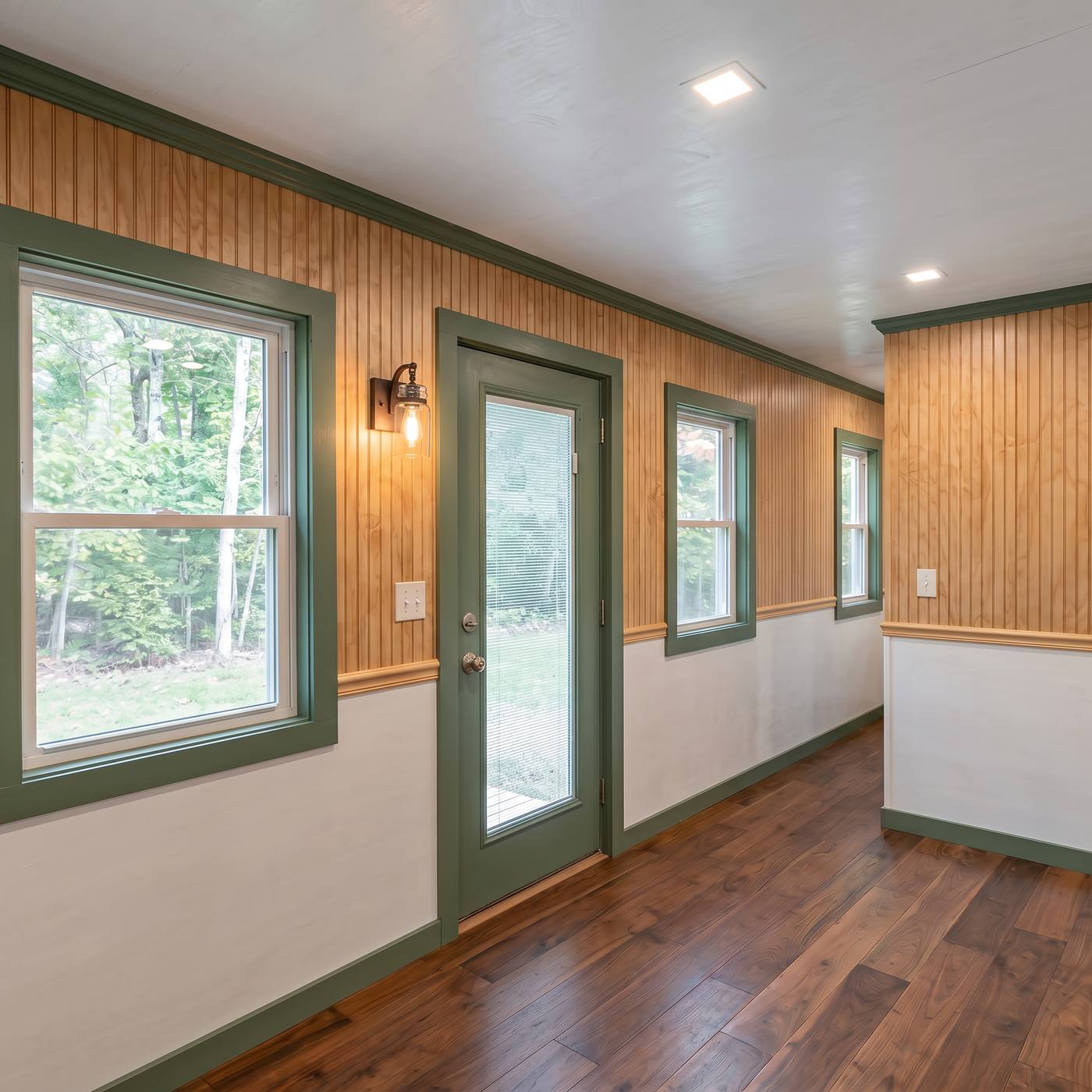 Classic 320 living area with rosemary green trim, chair molding and a full-light entry door
